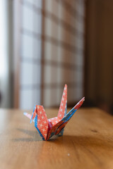 blue red and white origami, tsuru bird paper art on wooden table, japanese style decoration