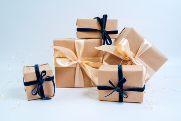 Christmas gifts in craft paper with a blue bow. Eco friendly trendy zero waste packaging, holiday...