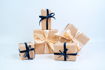 Christmas gifts in craft paper with a blue bow. Eco friendly trendy zero waste packaging, holiday...