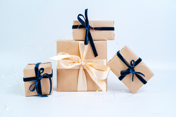 Christmas gifts in craft paper with a blue bow. Eco friendly trendy zero waste packaging, holiday...