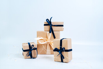 Christmas gifts in craft paper with a blue bow. Eco friendly trendy zero waste packaging, holiday...