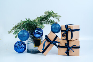 New Year's gifts in craft paper with a blue bow. Christmas tree with blue balls. Eco style. 