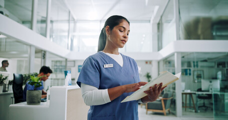 Nurse, documents and reading with woman in hospital for patient files, schedule and medical...