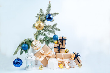 Christmas decor. Christmas tree branches, golden balls, gifts under the tree, candlestick