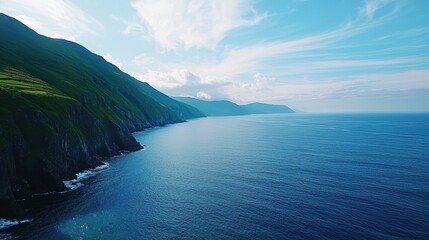 Obraz premium Breathtaking Aerial View of the Ring of Kerry Landscape in Ireland Featuring Lush Green Hills and Tranquil Blue Sea Under a Clear Sky