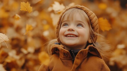 Fototapeta premium Happy child smiling and playing with falling autumn leaves in golden forest
