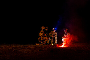 A group of military men in combat gear patrol in the middle of a desert and tropical jungle. Soldiers in full combat gear in dry weather conditions assemble and march on a mission.
