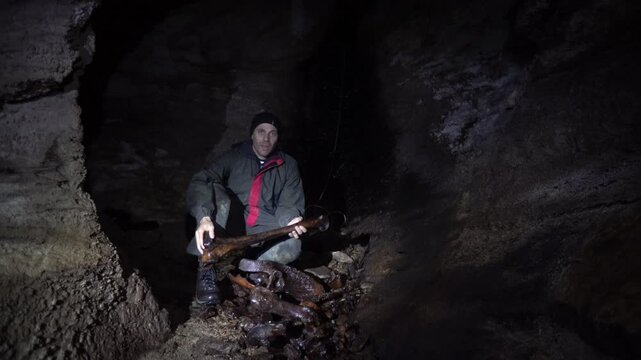 Caver displaying a large femur of the extinct giant moa bird that was found in a New Zealand cave