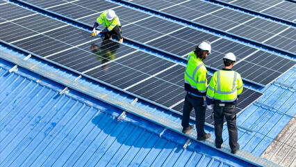 Worker Technicians are working to construct solar panels system on roof. Installing solar photovoltaic panel system. Men technicians walking on roof structure to check photovoltaic solar modules.