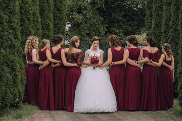 A group of women in red dresses are standing in a line, with one woman in the middle holding a...