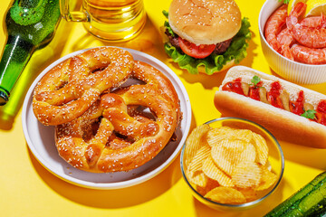 A vibrant photo showcasing a glass of beer surrounded by various snacks and fast food