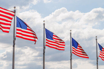 Rows of American flags waving against a blue sky