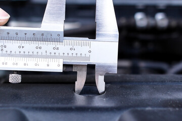 Close up of vernier caliper measuring engine component , Mechanics tool concept