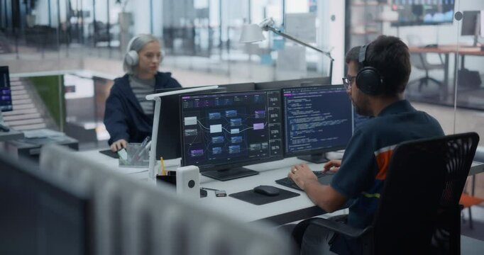 Software Development Department Working in a Cyber Security Artificial Intelligence Company. Young Web Engineer Working on a Computer with AI Model Visualization on Screen. Footage from the Back