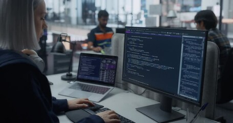 Portrait of a Thoughtful Engineer Working on Computer in a Technological Corporate Agency. Young Woman Writing Software Code for an Innovative Internet and Software as a Service Project - Powered by Adobe