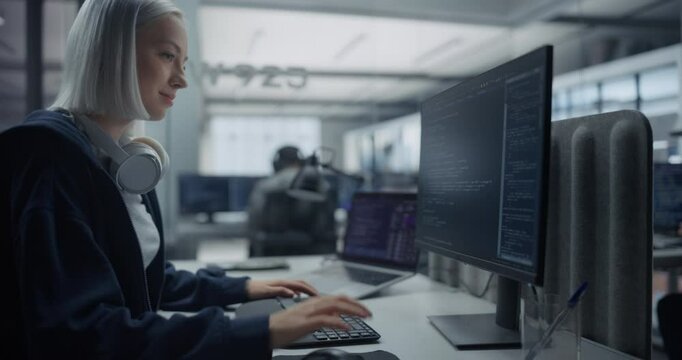 Female Software Developer Working on Computer in a Technological Laboratory, Writing Software Code. IT Programming Department Researching and Developing Commercial Internet Products. Zoom Out Footage