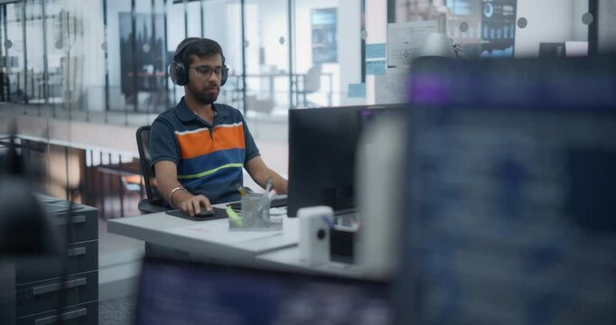 Portrait of an Indian Software Developer, Working on Desktop Computer Together with the Team in a Modern Glass Office, Writing Code and Managing Projects for a Corporate IT Partner