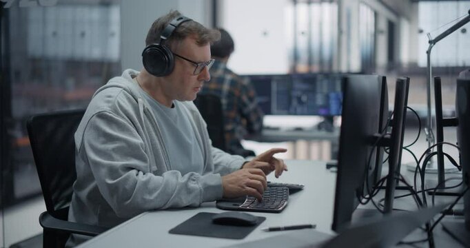 Portrait of a Male Software Developer Working on Computer in a Technological Office, Writing Software Code. IT Programming Department Researching and Developing Commercial Internet Products