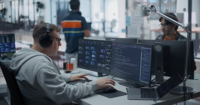 Male Software Developers Working in a Modern Glass Office, Using Computers and Laptops for Reviewing Lines of Code and Testing Artificial Intelligence Models to Optimize Their Project
