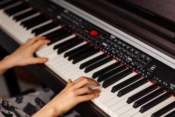 Fototapeta premium Close-up image of child's hands playing digital piano at home