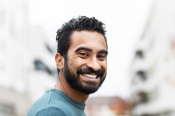 Portrait of a young man with a beard with fashionable houses