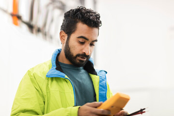 young engineer with beard checking with a device