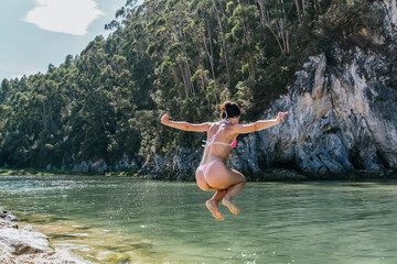Fototapeta premium young girl jumping into the river