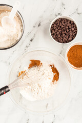 Flour, cinnamon, and chocolate chips set for baking pumpkin muffins