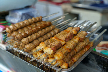 A tray of meat skewers is displayed on a table