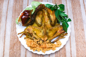 whole fried chicken with a sprinkling of Indonesian kremes. Served with shrimp paste chili sauce and fresh green vegetables