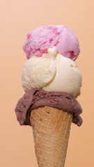 ice cream cone with three flavors chocolate, vanilla and strawberry.