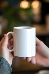 A close-up of a plain white coffee mug held by a person&rsquo;s hands, in a cozy caf&eacute; setting with blurred background, perfect for logo or quote mockups. 