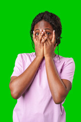 A young woman in a pink shirt covers her face with both hands against green background