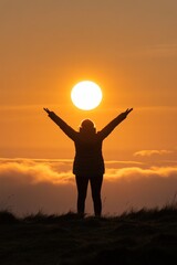 Fototapeta premium Silhouette of a person with arms raised against a vibrant sunset, symbolizing freedom, hope, and a connection to nature amidst a beautiful landscape.