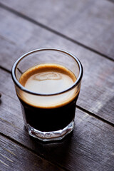 Coffee in glass cup on dark background. Close up. Copy space.
