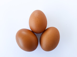 Three Brown Eggs on White Background