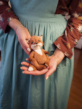 Woman in Vintage Apron Holding a Handmade Teddy Fox