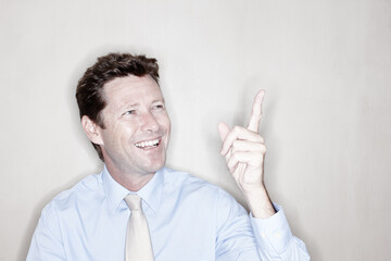 Laugh, businessman and pointing up at space in studio for mockup promotion, advertising or show commercial. Mature, worker or hand gesture for presentation, sales discount or marketing on background