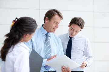 Collaboration, documents and review with business people in corporate workplace for discussion. Conversation, game plan or meeting with man and woman employee group in office together for strategy