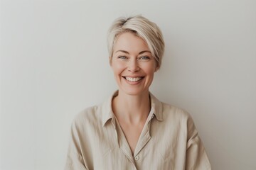 Fototapeta premium The charming woman exudes confidence and elegance with a chic beige shirt and short blonde hair, blending warmth and style in her look effortlessly, showcasing grace and sophistication