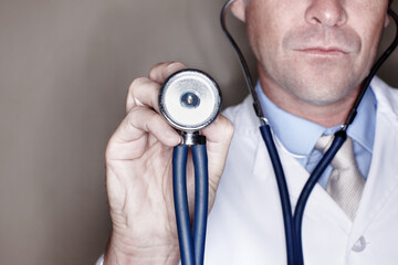 Man, doctor and hand with stethoscope in studio background for healthcare, consultation and support. Male person, employee and help as medical professional for evaluation, heartbeat and checkup