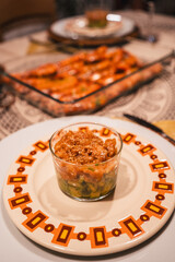 A glass of food is on a plate with a colorful pattern