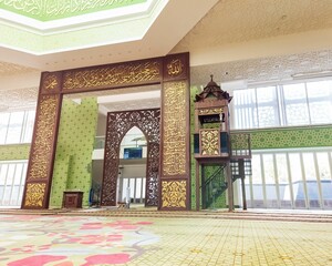 interior of a mosque with elaborate Islamic calligraphy, a minbar, and exquisite decorations.