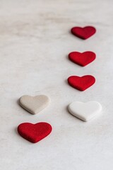Obraz premium A row of five hearts, two of which are red and three of which are white. The red hearts are placed in the middle of the row, with the white hearts on either side. Concept of love and affection