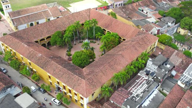 Colegio Nacional Pinillos. As we fly above, the historic architecture of the school comes into view, with its colonial-style arches, red-tiled roofs, and open courtyards.