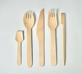 Set of bamboo wooden kitchenware eating utensil spoon, spork, fork, knife, and skewer stick object with no food isolated on horizontal white background.