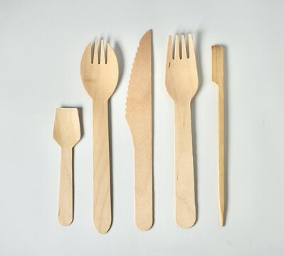 Set of bamboo wooden kitchenware eating utensil spoon, spork, fork, knife, and skewer stick object with no food isolated on horizontal white background. - Powered by Adobe