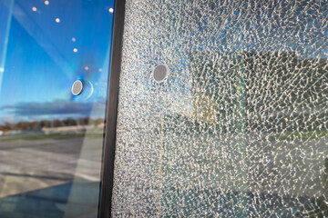 Damaged building facade with shattered multilayer glass, requiring replacement. Safety glass holds...
