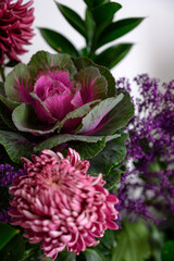 Obraz premium Stylish bouquet of lilac cabbage, purple chrysanthemums, Purple flower. Purple flowers background and texture. Text space