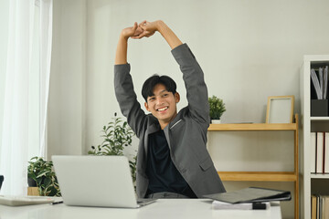 Relaxed office worker stretching after work session in the workplace